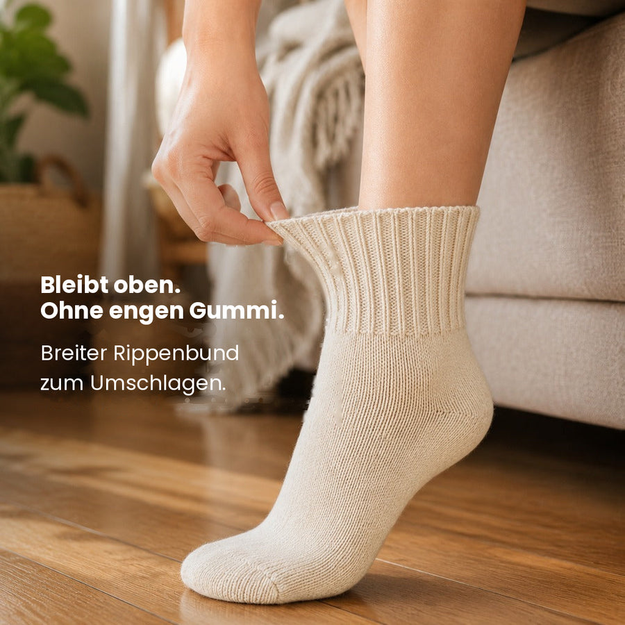Hand zieht den breiten Umschlagbund über den Knöchel
