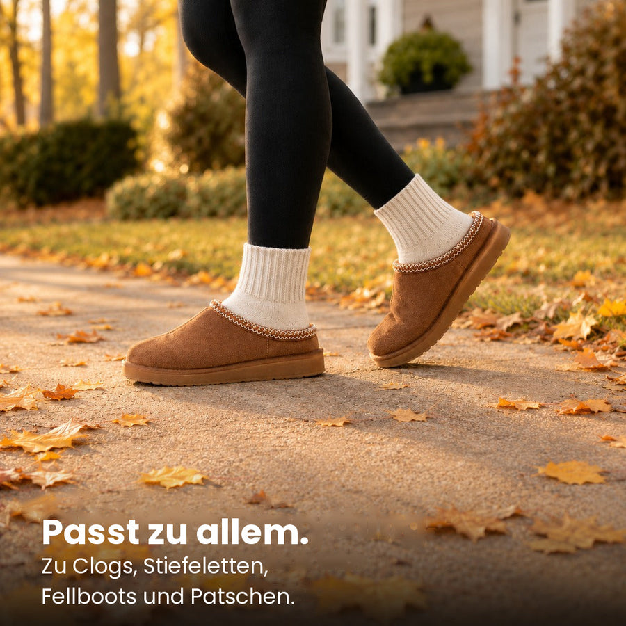 Frau in Leggings und Clogs auf herbstlichem Weg, cremefarbene Socken